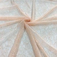 Tissu dentelle extensible au mètre, par Longan Craft France, présenté à plat avec motif floral et plis centraux étoilés. Cette dentelle multicolore de haute qualité est délicate, idéale pour vêtements, lingerie et jupes.