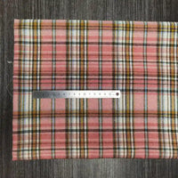 Un tissu en flanelle à carreaux colorés de Longon Craft France est posé sur une surface grise avec une règle métallique de 20 cm. Cette flanelle polyester-coton ultra-douillette est idéale pour l'automne et parfaite pour la confection de vêtements.