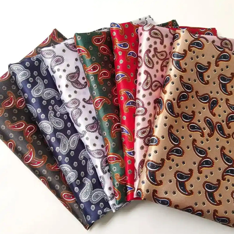 Six pièces de tissu pliées à motif cachemire sont disposées en éventail. Les tissus sont de couleur noire, blanche, verte, rouge, rose et beige, et présentent tous des motifs similaires.