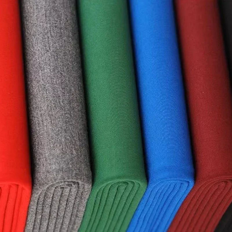 Cinq tissus pliés de couleur rouge, gris, vert, bleu et bordeaux sont disposés verticalement en rangée. Les bords des tissus sont visibles, montrant leur épaisseur et leur texture.