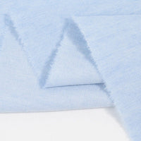 Gros plan sur le Tissu jean 100% coton au mètre de Longan Craft France : denim léger 4,5 oz bleu clair, à texture douce et légère avec bords légèrement effilochés.