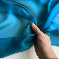 Un présentoir de luxe "Mousseline de soie de mûrier" bleu vif de Longan Craft France - un tissu léger en pure soie de mûrier avec des plis doux, idéal pour la confection de vêtements.