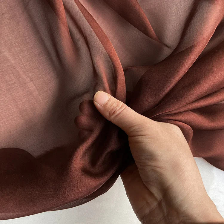 La Mousseline de soie de mûrier de luxe au mètre de Longan Craft France est froncée à la main. Elle révèle sa pureté naturelle, sa légèreté et sa translucidité, idéales pour les vêtements élégants.