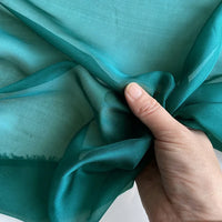 Mousseline de soie de mûrier de luxe au mètre de Longan Craft France, froncée à la main, montrant la texture légère et semi-transparente de ce tissu vestimentaire naturel et pur sur un fond clair.