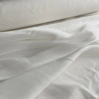 Un gros plan sur le Tissu soie et lin 14 mamans au mètre de Longan Craft France montre un organza de soie de mûrier lisse et subtilement brillant, doucement drapé et superposé, mettant en valeur sa légère translucidité - idéal pour des créations estivales pleines de vie.