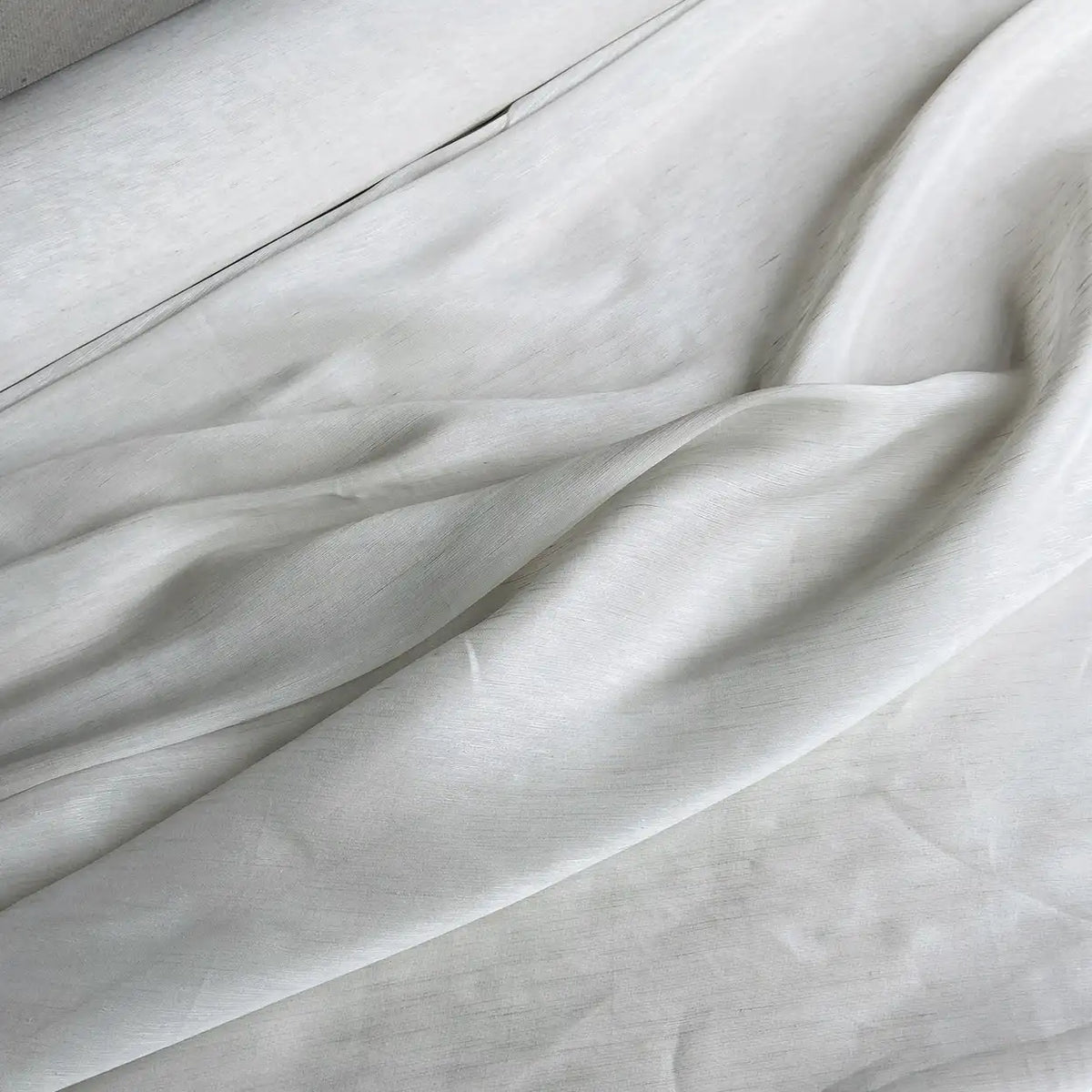 Gros plan sur le tissu soie et lin 14 mamans au mètre de Longan Craft France, un organza de soie de mûrier aux plis souples et à la texture subtile, idéal pour l'été et disponible dans des couleurs vibrantes.