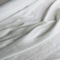 Gros plan sur le tissu soie et lin 14 mamans au mètre de Longan Craft France, un organza de soie de mûrier aux plis souples et à la texture subtile, idéal pour l'été et disponible dans des couleurs vibrantes.