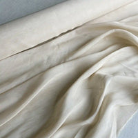 Un gros plan du Tissu soie et lin 14 mamans au mètre de Longan Craft France montre des plis doux et une surface lisse et légèrement texturée. Cet organza de soie de mûrier vibrant est idéal pour les projets d'été.