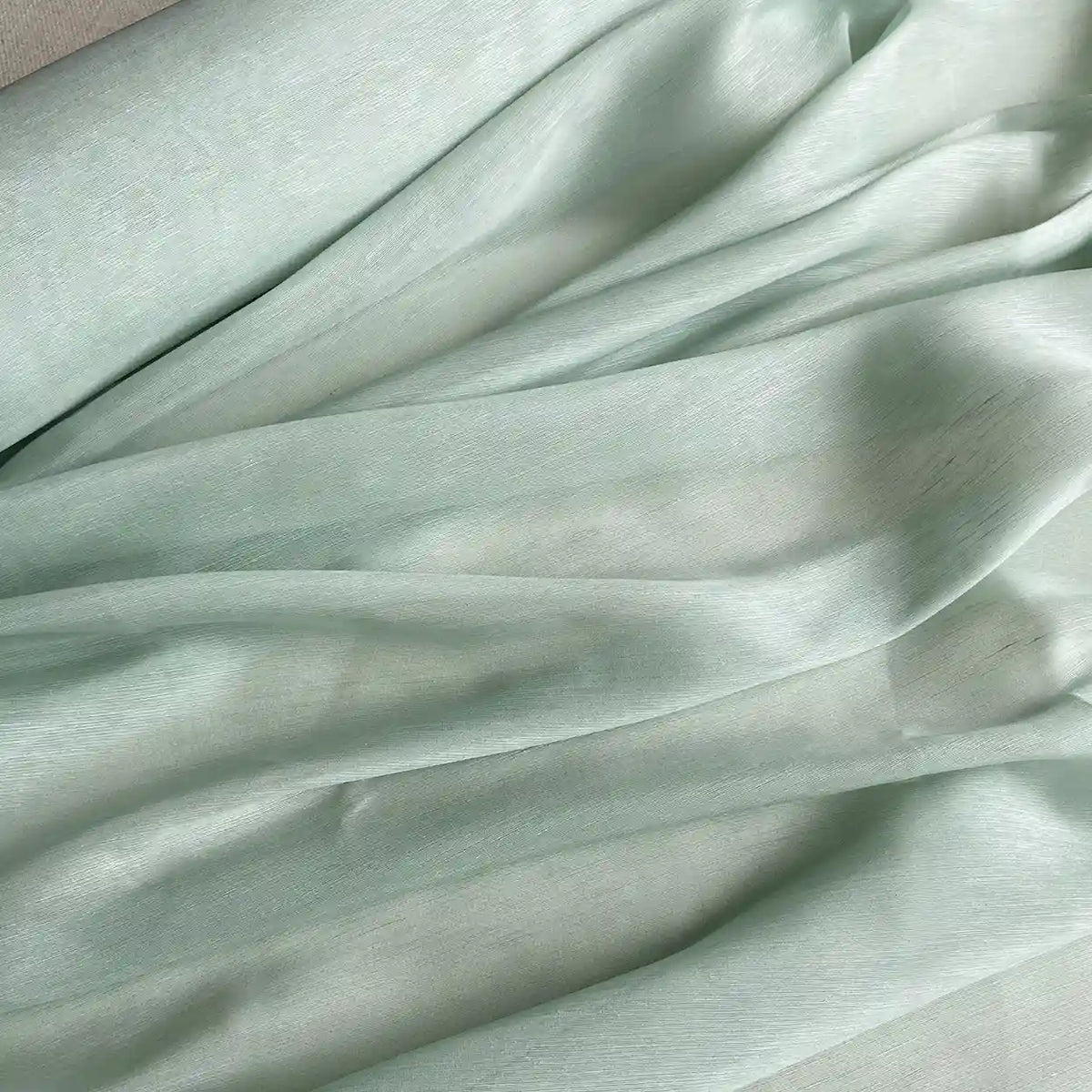 Le Tissu soie et lin 14 mamans au mètre de Longan Craft France est composé d'organza de soie de mûrier vert clair, drapé en plis aériens avec des ombres douces et une texture lisse et légèrement brillante - parfait pour les créations estivales.