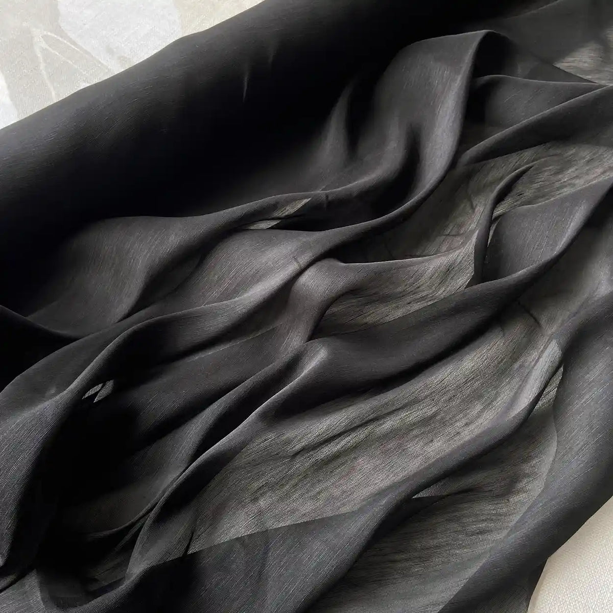 Gros plan sur Tissu soie et lin 14 mommes de Longan Craft France, un organza de soie de mûrier semi-transparent aux plis souples et fluides et à la texture lumineuse, idéal pour l'été avec sa légèreté luxueuse et sa couleur vibrante.