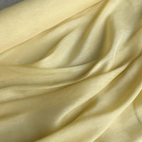 Gros plan sur le Tissu soie et lin 14 mommes de Longan Craft France : un organza de soie de mûrier jaune clair, délicatement drapé en plis doux, avec une texture lisse et légèrement brillante, parfaite pour l'été.