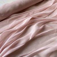 Un gros plan sur le Tissu soie et lin 14 mamans au mètre de Longan Craft France met en évidence sa texture luxueuse, ses couleurs vibrantes et sa translucidité aérienne - un tissu organza de soie de mûrier idéal pour les vêtements d'été.