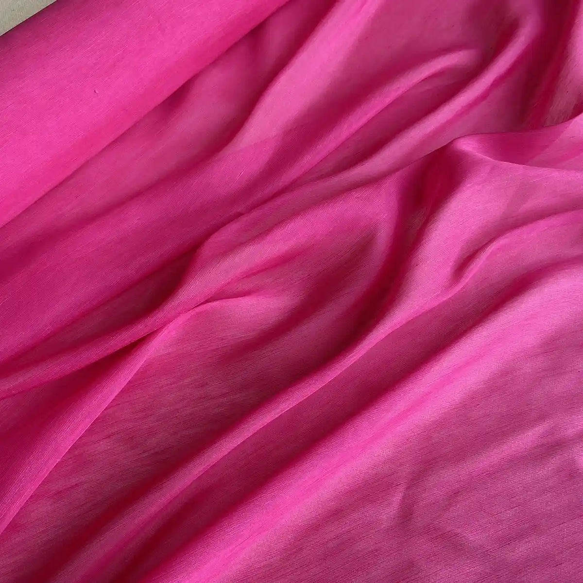 Un rose vibrant Tissu soie et lin 14 mommes de Longan Craft France, avec des plis doux et fluides et une texture riche, apporte une touche luxueuse à n'importe quel décor - l'organza de soie de mûrier parfait pour l'été.