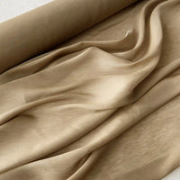 Un rouleau de Tissu soie et lin 14 mommes de Longan Craft France, partiellement déroulé sur une surface plane, présente des plis doux et l'élégance de ce luxueux organza de soie de mûrier vibrant, idéal pour l'été.