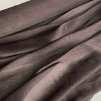 Gros plan sur Tissu soie et lin 14 mamans au mètre de Longan Craft France, qui présente un organza de soie de mûrier gris brunâtre aux plis visibles, à la texture naturelle et aux reflets lumineux - le luxe léger idéal pour l'été.