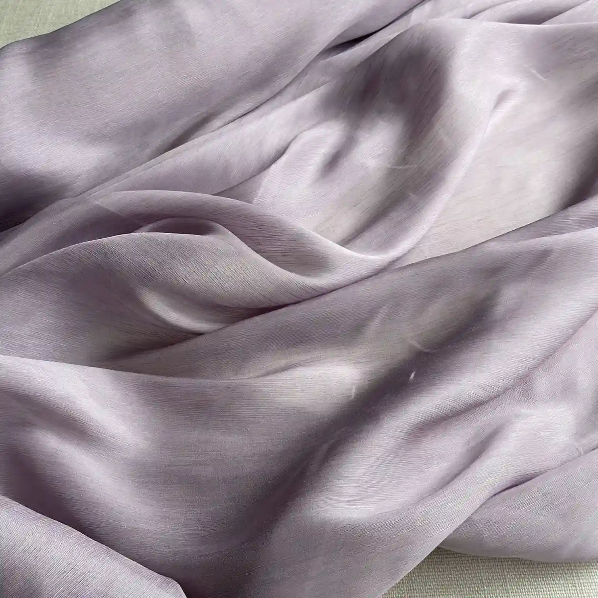 Gros plan sur le Tissu soie et lin 14 mommes violet clair de Longan Craft France, un organza de soie de mûrier transparent et légèrement froissé, aux plis doux et aux ombres légères - idéal pour les projets d'été.