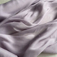 Gros plan sur le Tissu soie et lin 14 mommes violet clair de Longan Craft France, un organza de soie de mûrier transparent et légèrement froissé, aux plis doux et aux ombres légères - idéal pour les projets d'été.