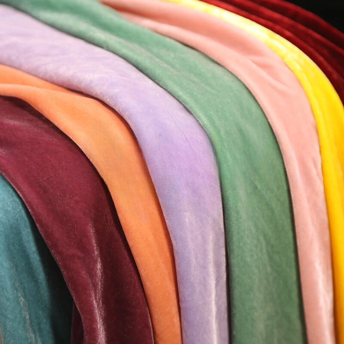 Le tissu Velours de soie de mûrier doux de Longan Craft France en sarcelle, bordeaux, orange, lavande, vert, rose, jaune et rouge est drapé en plis doux - idéal pour les tissus d'ameublement ou les projets de couture créatifs.