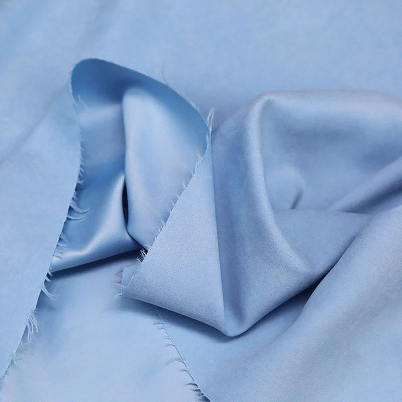 Gros plan sur le Longan Craft France microsuède polyester multicolore au mètre, tissu peau de pêche brossée doux, aux bords effilochés, posé à plat et délicatement plié.