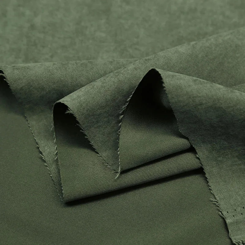 Gros plan sur la superposition de Microsuède polyester multicolore au mètre de Longan Craft France, montrant la texture brossée douce et semblable à la peau de pêche, la finition mate et les bords légèrement effilochés, idéaux pour des vêtements confortables.