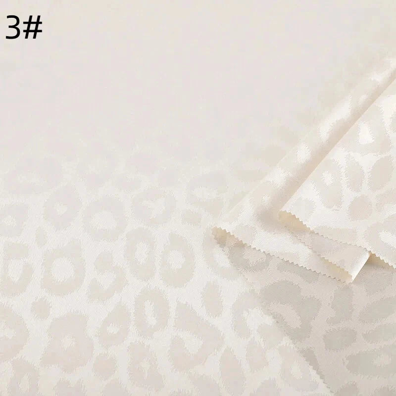 Gros plan du Tissu satin jacquard léopard au mètre de Longan Craft France, montrant un tissu blanc cassé superposé avec un motif léopard subtil. Le numéro "3#" est visible en haut à gauche. Textile idéal pour les chemises en satin DIY.