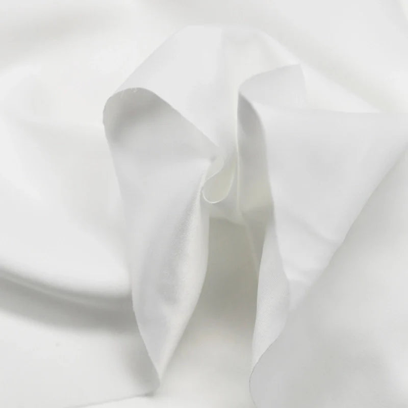 Gros plan sur Microsuède polyester multicolore au mètre de Longan Craft France, qui présente une texture peau de pêche brossée avec des plis doux et des ombres légères - un tissu doux idéal pour vêtements et décoration.