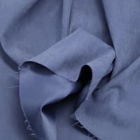 Gros plan sur le polyester microsuède multicolore, doux et froissé, aux reflets subtils et aux bords effilochés. Le tissu peau de pêche brossée de Longan Craft France, parfait au mètre pour vêtements et décoration.