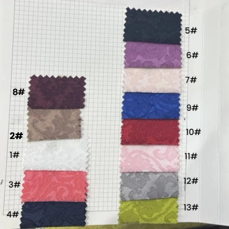 Une carte d'échantillons de Longan Craft France présente treize échantillons de tissu jacquard damassé multicolore à motif floral, disposés en deux colonnes et numérotés de 1# à 13# sur le côté droit de chaque échantillon.