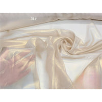 Un tissu mousseline métallisé, brillant, ivoire ou champagne, touché à la main par Longan Craft France, drapé sur une surface plane et portant la mention "31#" en haut à gauche.