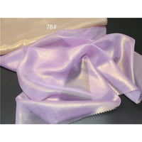 Un tissu mousseline violet clair et brillant, métallisé au mètre par Longan Craft France, est drapé sur une surface sombre avec un tissu beige au-dessus. L'image montre le numéro "78#".