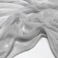 Gros plan sur le tissu mousseline plissé brillant au mètre de Longan Craft France - un tissu de polyester léger, brillant et froissé - posé librement sur une surface.