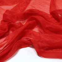 Gros plan sur le tissu de polyester plissé mousseline multicolore, transparent et léger de Longan Craft France, dont la texture subtilement froissée est drapée en plis souples sur une surface blanche.