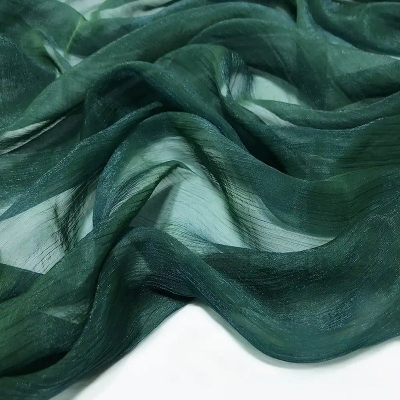 Le plissé mousseline au mètre de Longan Craft France, un tissu léger en polyester multicolore à la texture brillante et froissée, est présenté drapé en plis fluides sur du blanc pour mettre en valeur sa translucidité aérienne.