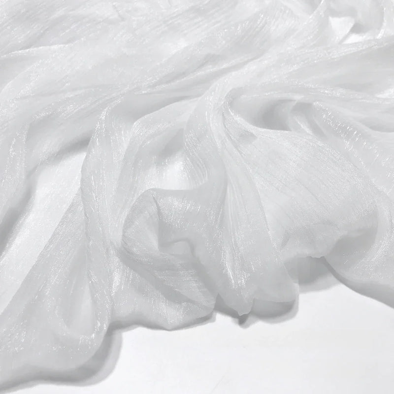 Le Tissu mousseline plissé brillant de Longan Craft France est un tissu polyester léger, froissé et subtilement brillant, parfait pour une tenue de soirée élégante. Drapée librement, ses plis semi-transparents mettent en valeur sa texture raffinée.