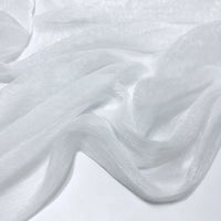 Gros plan sur le tissu polyester plissé mousseline multicolore de Longan Craft France, à la texture diaphane et semi-transparente et aux légers plis, drapé librement sur une surface plane.