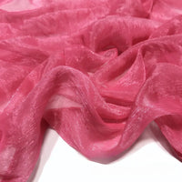Gros plan sur le Tissu mousseline plissé brillant au mètre de Longan Craft France, un tissu léger et brillant en polyester plissé, présenté en plis souples sur une surface blanche.