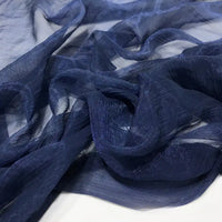 Gros plan sur du Tissu mousseline plissé brillant au mètre, bleu marine, semi-transparent et froissé, de Longan Craft France, montrant sa surface légèrement texturée sur un fond clair.