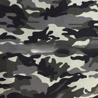 Un gros plan du tissu toile imprimé camouflage au mètre de Longan Craft France montre des motifs noirs, gris et blancs avec une couture horizontale - un matériau de haute qualité idéal pour les vêtements, les sacs à main, les tentes, les chapeaux et les chaussures.