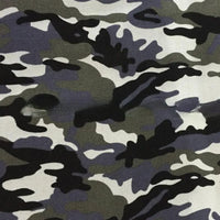Un gros plan du tissu toile imprimé camouflage au mètre de Longan Craft France montre deux déchirures visibles dans le tissu polyester-coton, qui présente des nuances de noir, de gris et de blanc - idéal pour les vêtements, les sacs à main ou les tentes.