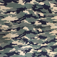 Un gros plan de Tissu toile imprimé camouflage au mètre de Longan Craft France montre une toile polyester-coton verte, beige et noire avec un pli central subtil, mettant en valeur sa texture - idéale pour les vêtements, les sacs, les tentes et plus encore.