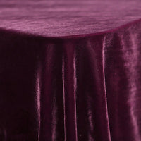Gros plan sur une table ronde recouverte de Velours de soie de mûrier doux de Longan Craft France, un tissu d'ameublement en velours de soie-rayon mauve à la texture lisse et aux plis doux, idéal pour l'ameublement, la couture et les projets créatifs.