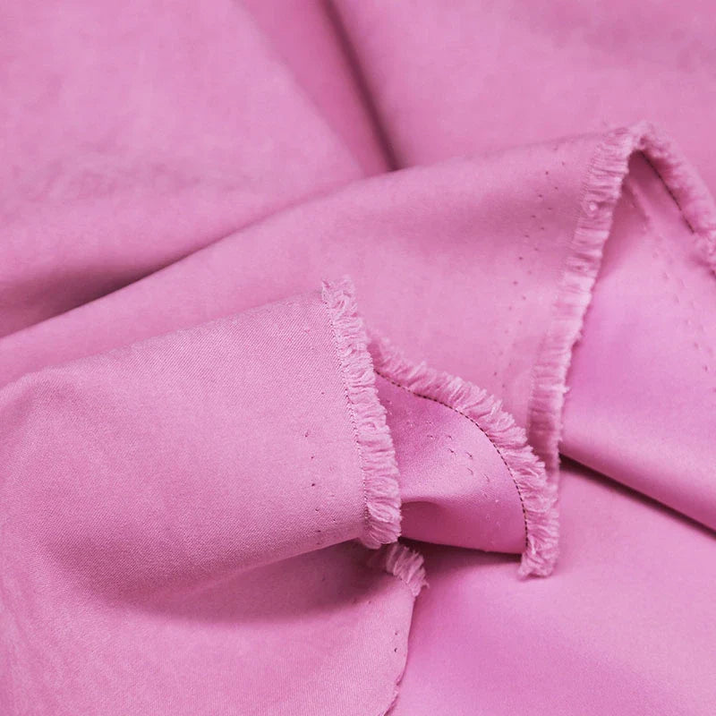 Gros plan sur Longan Craft France microsuède polyester multicolore au mètre, tissu peau de pêche brossée doux et agréable, idéal pour vêtements ou décoration, montrant sa texture souple et ses bords effilochés.