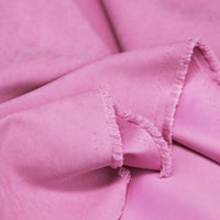 Gros plan sur Longan Craft France microsuède polyester multicolore au mètre, tissu peau de pêche brossée doux et agréable, idéal pour vêtements ou décoration, montrant sa texture souple et ses bords effilochés.