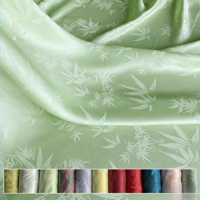 Un gros plan du Tissu soie de mûrier et bambou imprimé jacquard de Longan Craft France montre un subtil motif de feuilles. Ci-dessous, douze échantillons de couleurs - du blanc au rouge et au bleu - mettent en valeur ce tissu doux et multicolore en soie-rayon.