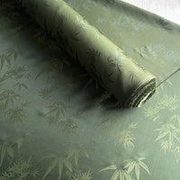 Un rouleau de Tissu soie de mûrier et bambou imprimé jacquard au mètre de Longan Craft France est partiellement déroulé, révélant son doux et confortable mélange de soie et de rayonne multicolore avec un motif complexe de bambou.