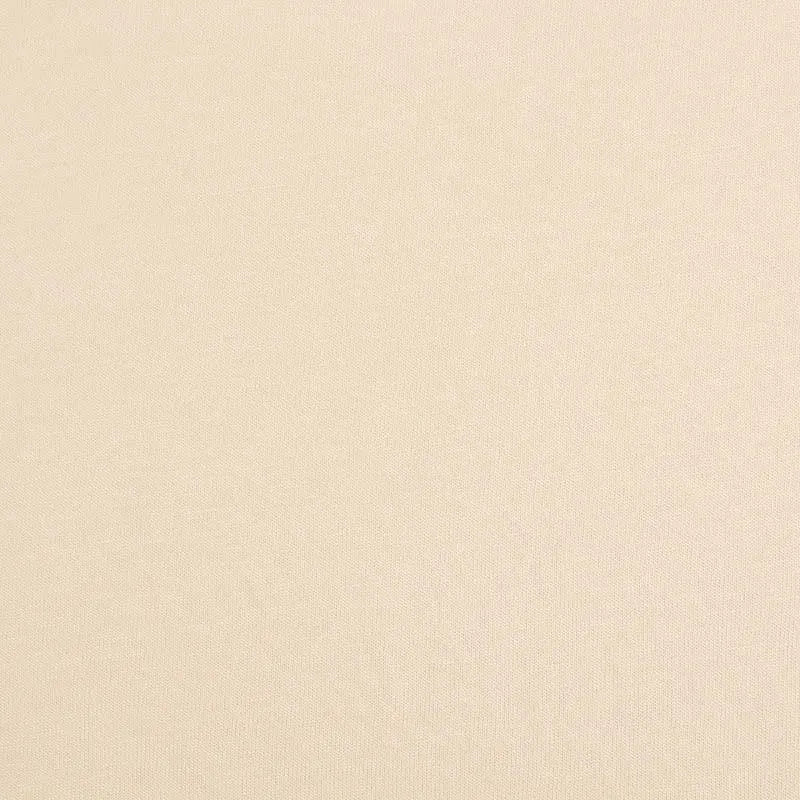 Une surface beige lisse et uniforme comme le "Jersey bambou uni avec élasthanne au mètre" de Longan Craft France, un tissu jersey doux idéal pour les vêtements d'intérieur, sans motifs ni marques visibles.