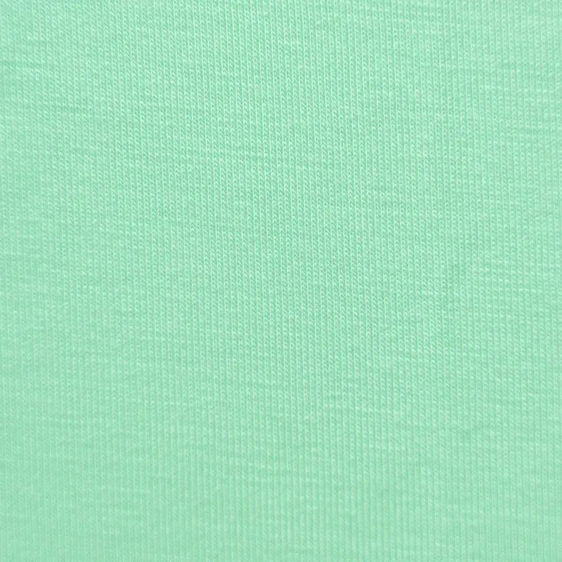 Gros plan sur le Jersey bambou uni avec élasthanne au mètre de Longan Craft France, un tissu côtelé vert clair et doux aux coutures soignées, idéal pour les vêtements d'intérieur et les vêtements de bébé grâce à ses propriétés antibactériennes.
