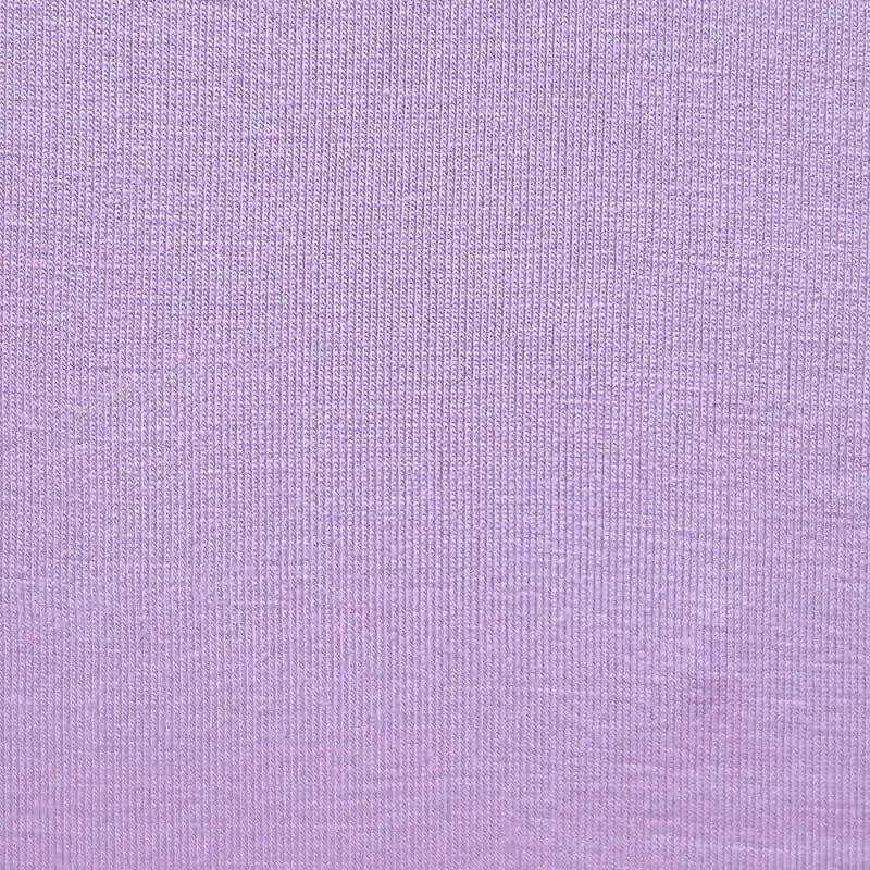 Gros plan sur le Jersey bambou uni avec élasthanne au mètre de Longan Craft France, un doux jersey violet clair idéal pour les vêtements d'intérieur, montrant sa texture fine et régulière et son motif de tissage visible.