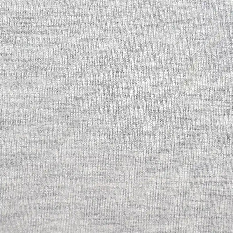 Un gros plan sur le Jersey bambou uni avec élasthanne de Longan Craft France montre sa texture gris clair, chinée et son tissage fin - ce doux textile au mètre est idéal pour les vêtements d'intérieur.