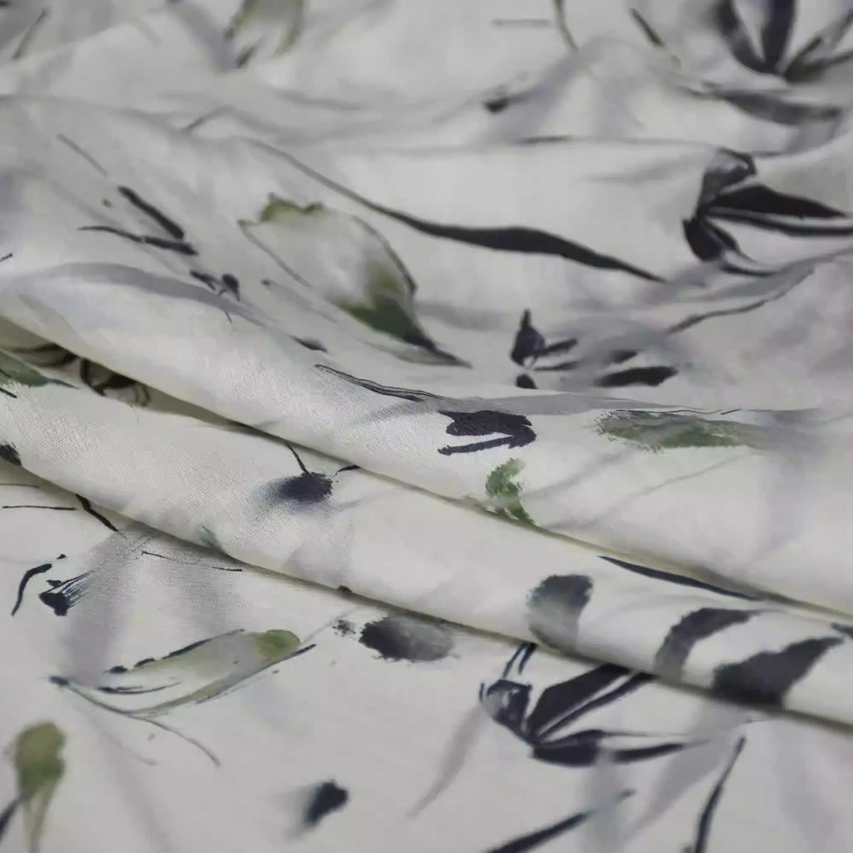 Gros plan sur le Tissu viscose imprimé bambou au mètre de Longan Craft France, une viscose légère de style chinoiserie avec un subtil motif abstrait noir et vert discret - idéal pour les peignoirs de qualité et les confections élégantes.